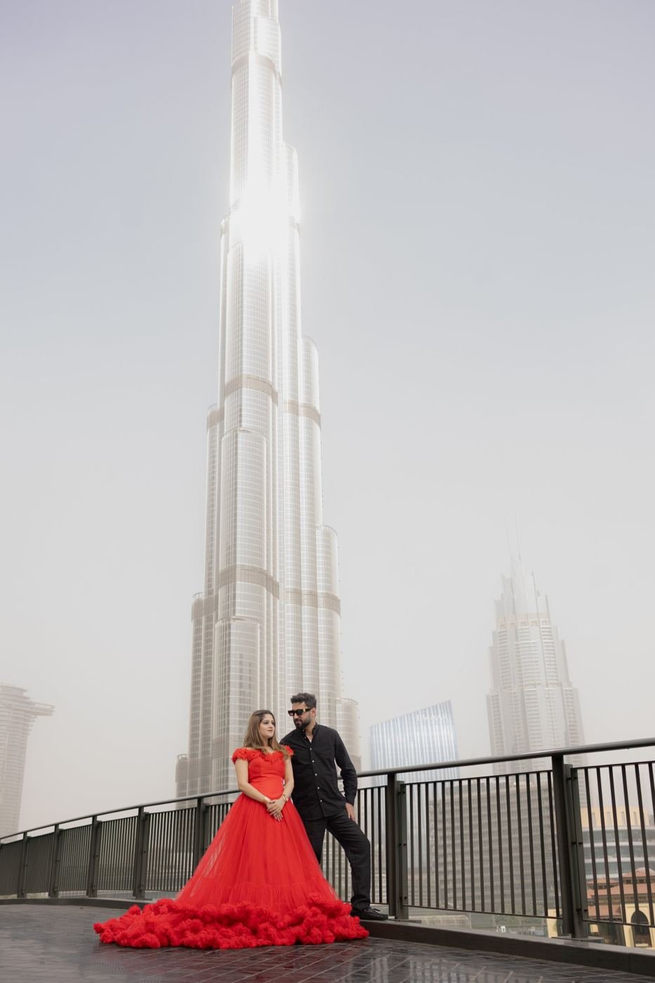 Couple in a red gown and black suit in front of Burj Khalifa